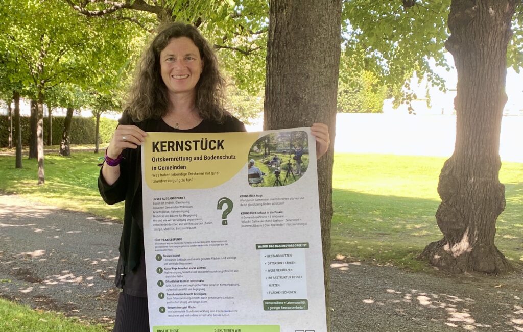 Ulrike Feichtinger vom Klimabündnis und Bodenbündnis Österreich mit einem Plakat zum Film KERNSTÜCK.